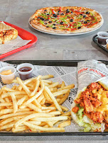 Pizzas, frites et sandwich poulet croustillant sur un plateau
